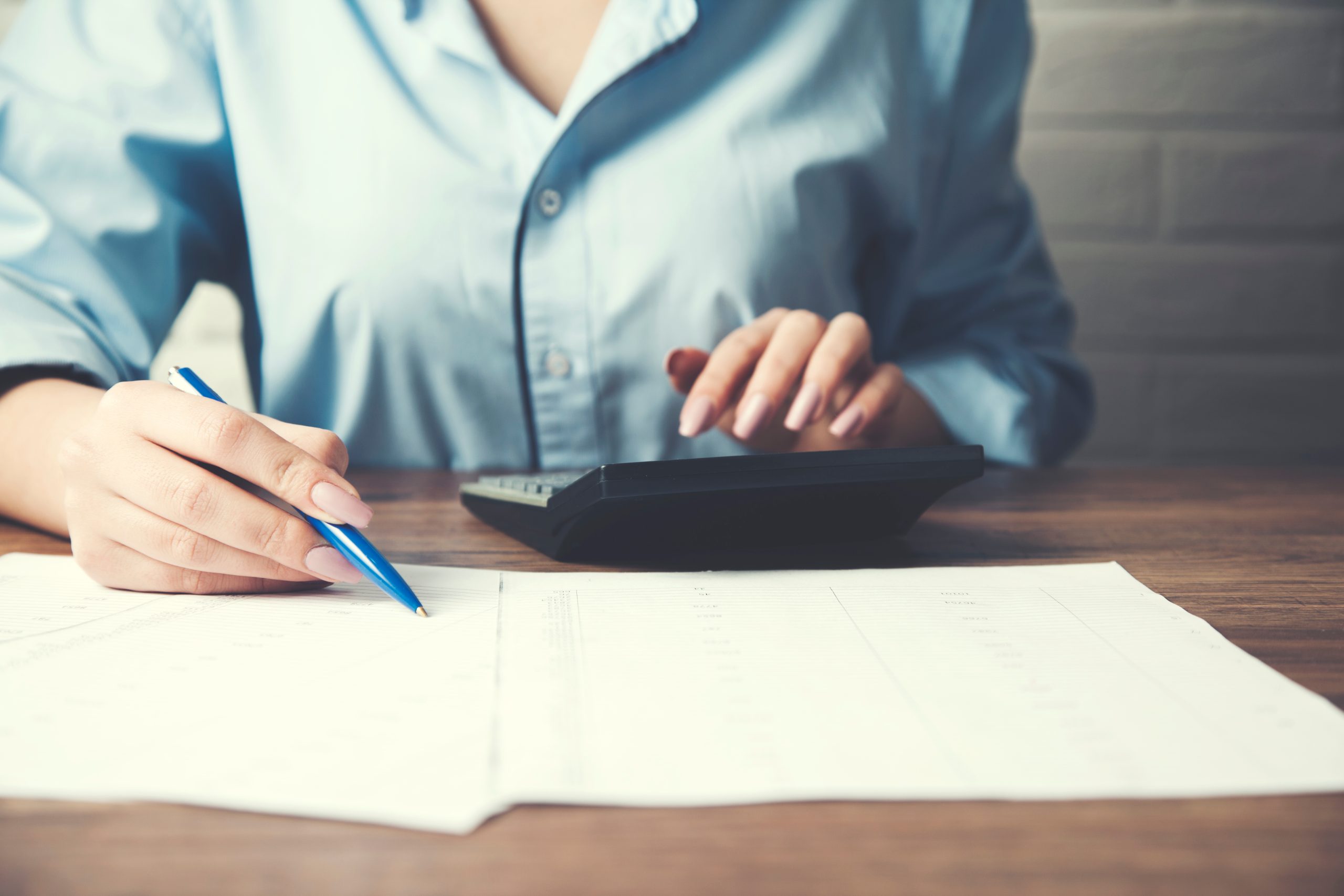 businesswoman hand document and calculator on office desk