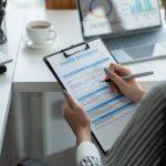 Woman filling out paperwork for small business health insurance