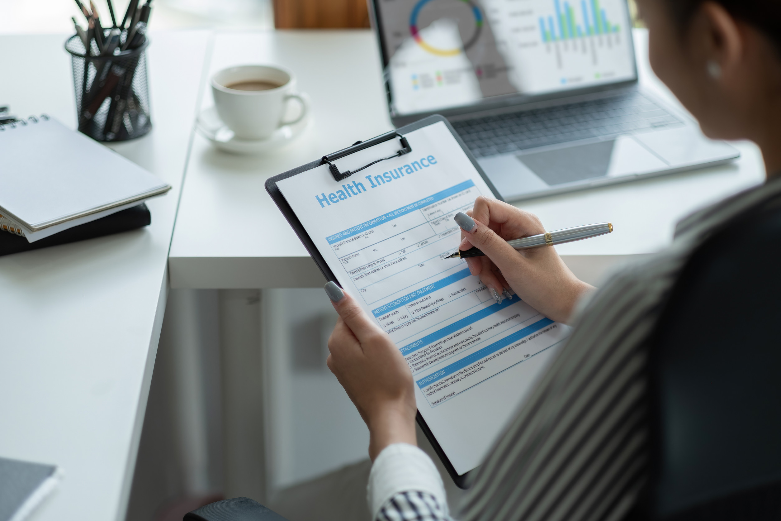 Woman filling out paperwork for small business health insurance